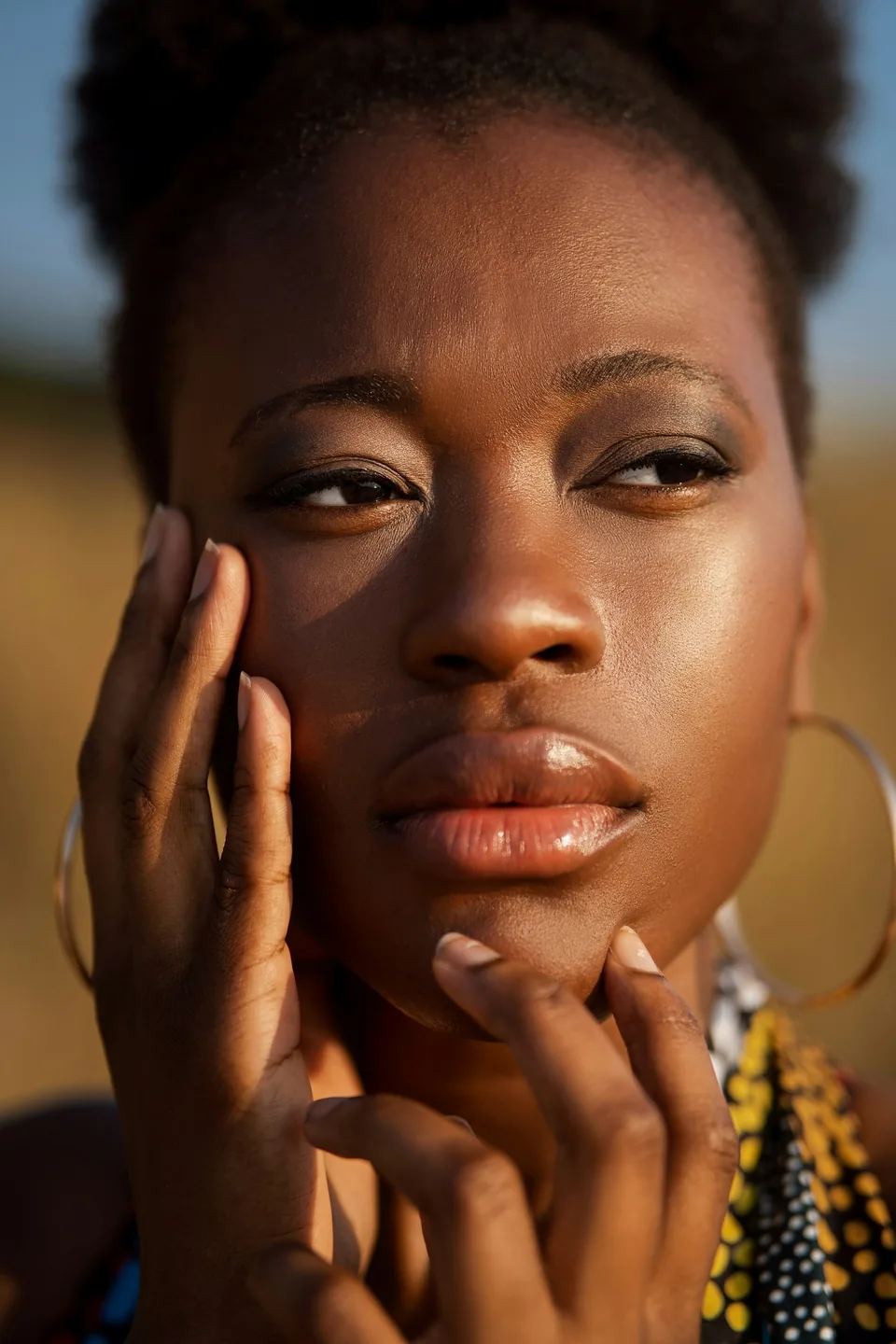 Close-up of a woman's face with hands near her chin