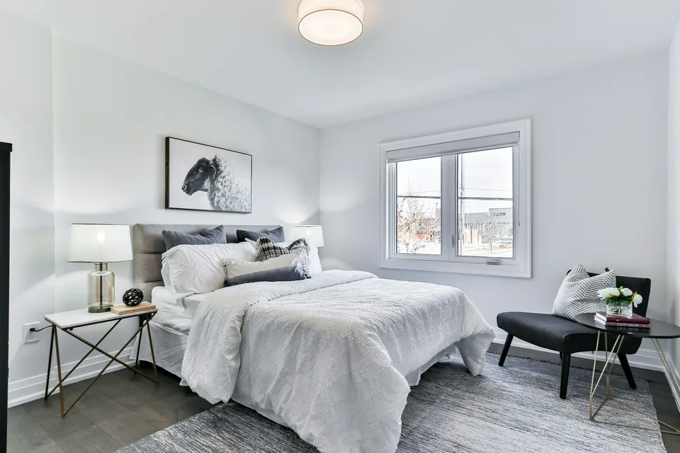 Bed with white sheets in a room